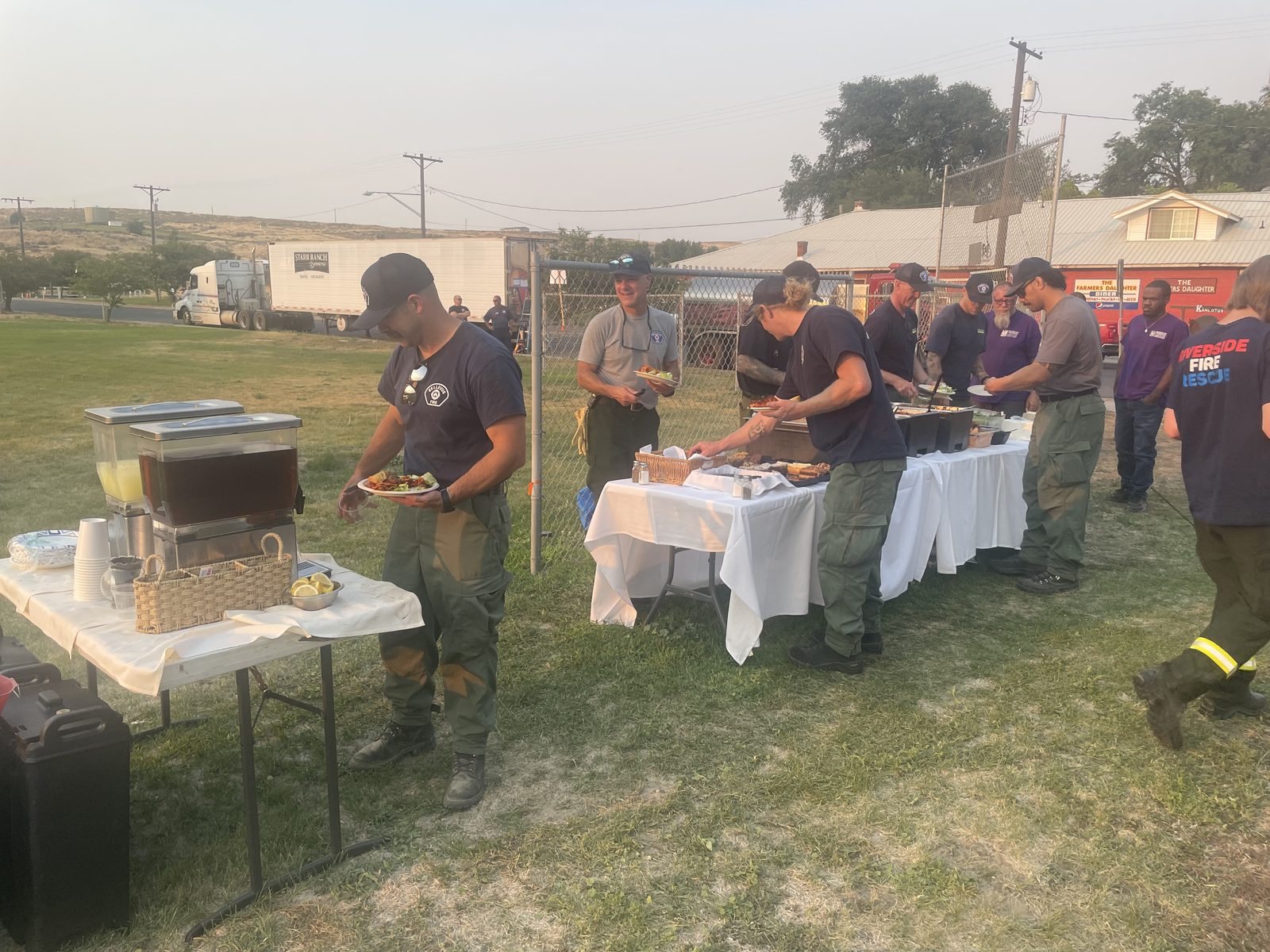 Firefighters serving themselves dinner with lemonade and iced tea at a CG Public House & Catering buffet during the Lyons Ferry Fire response near Kahlotus, Washington
