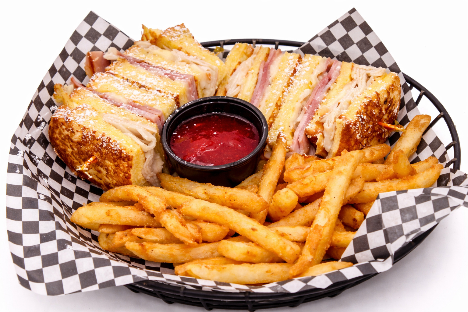 Monte Cristo sandwich dusted with powdered sugar, served with fries and raspberry jam