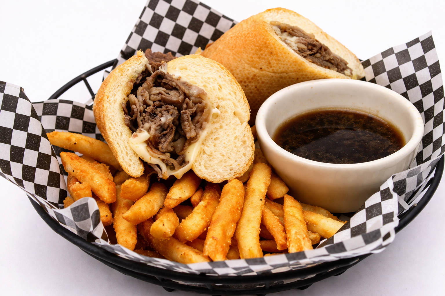 Prime rib dip sandwich on a toasted roll with melted cheese, seasoned fries and a cup of au jus